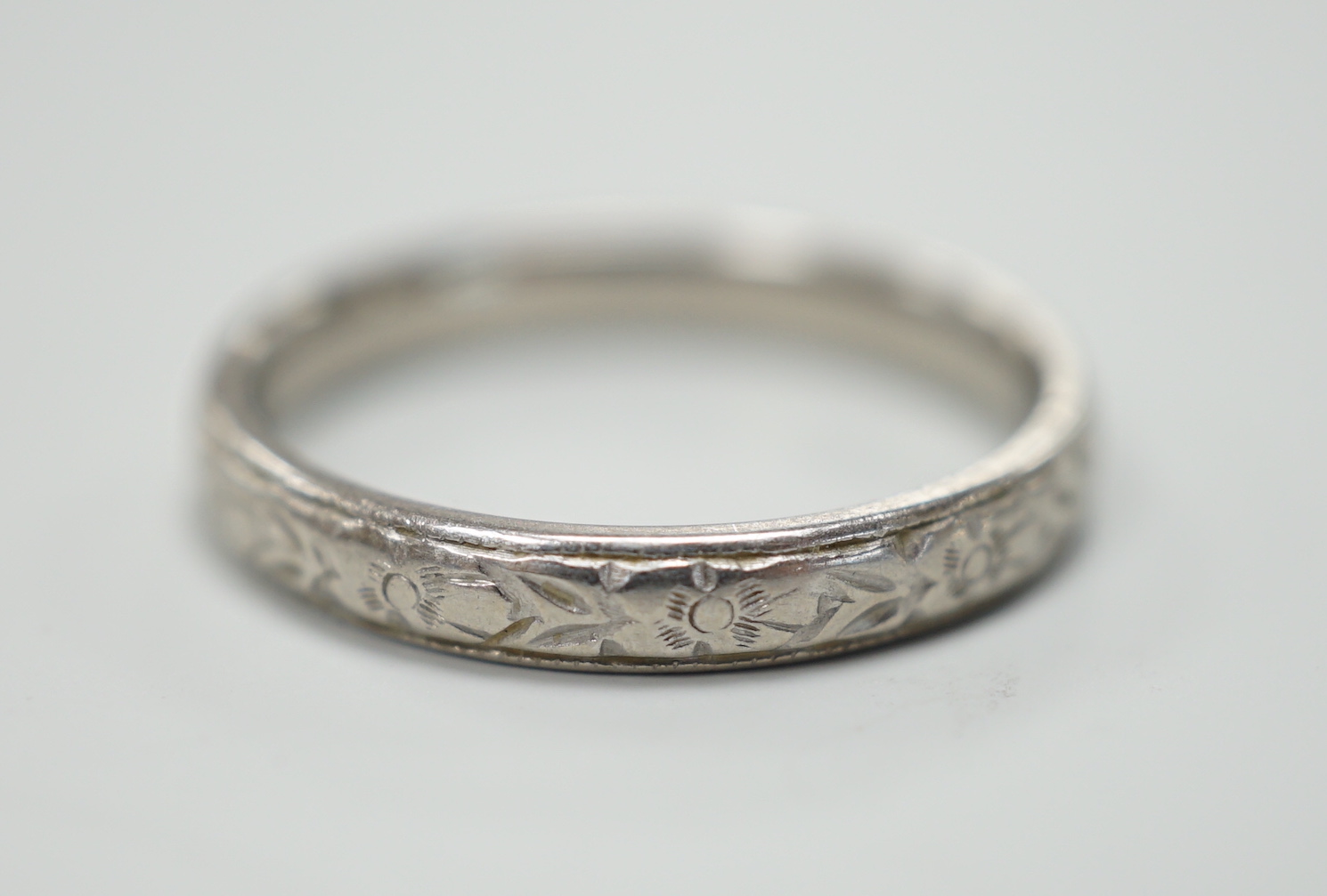 An engraved platinum wedding band, size M, 4.3 grams.